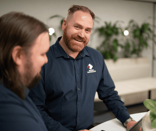 Two professionals from Bigfish discussing work in a modern office setting.