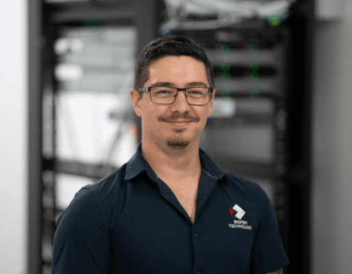 Technician in server room wearing Bigfish Technology polo shirt.